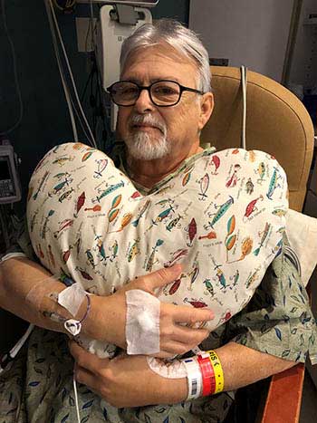Triple bypass patient from Methodist Hospital Texsan holding heart pillow to help with recovery.