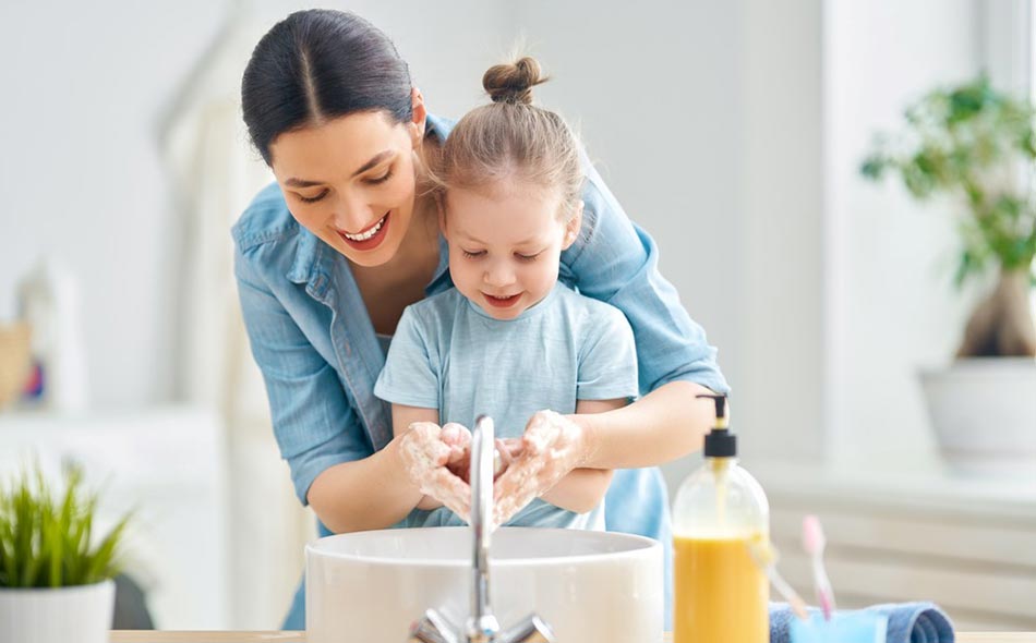 A cute little girl and her mother are washing their hands. Protection against infections and viruses. A mom builds healthy class=