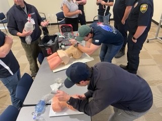 Students practicing CPR with device on CPR manikin