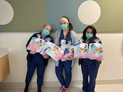 Nurses holding gifts for NICU patients.