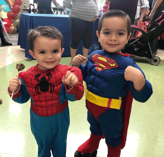 two small children in Spider-Man and Superman costumes