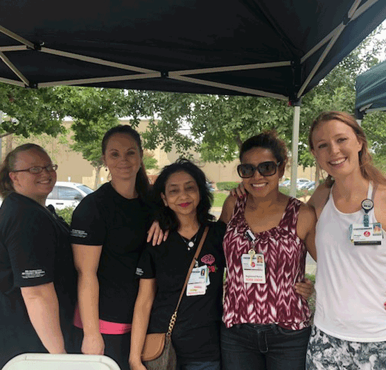 a group posing under a tent at the Health Awareness and Wellness Fair