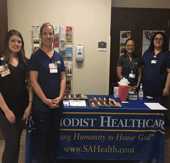 hospital staff around a Methodist Healthcare table at an event